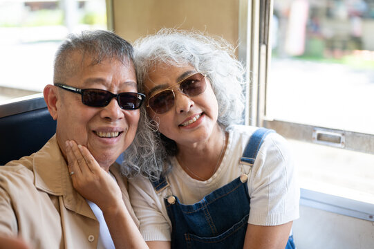 Asian senior couple enjoying an intimate moment together on a train