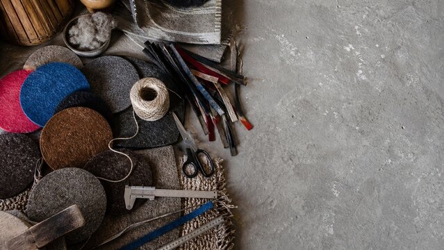 assorted felt fabric circles, tailoring tools, sewing supplies, professional craft workshop, concrete background, textile production materials