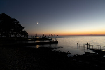 Obraz premium Crescent Moon Over Adriatic Sea at Dusk with Traditional Fishing
