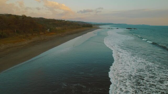 Long stretch of Ostional Beach meets Pacific Ocean during twilight in Costa Rica