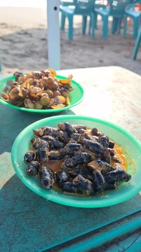 Traditional West Sumatran Minangkabau Culinary Dishes Langkitang and Pensi Freshwater Snails and Clams Served on Beach Table