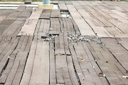 Warped and damaged hard wood platform floor due to prolonged exposure to rain and extreme weather