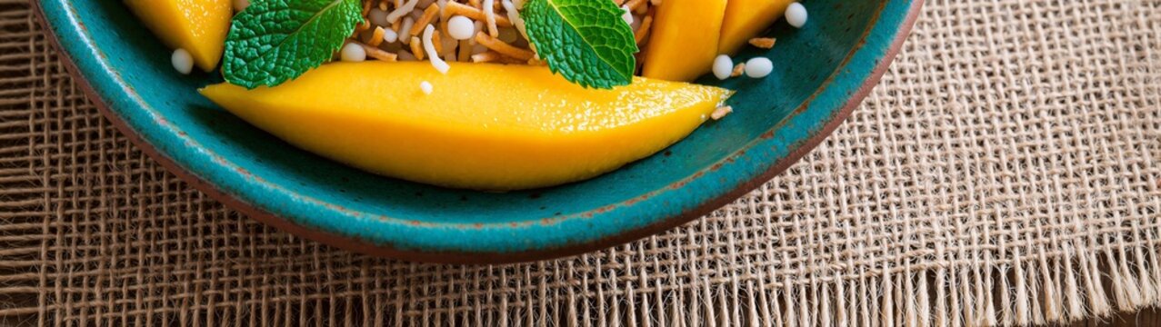 Mango rice pudding bowl with mint on burlap table setting