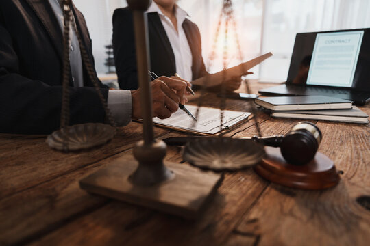 Lawyers reviewing contract with legal justice symbols