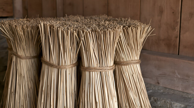 Cut ends of tied water reed bundles stacked against a wall