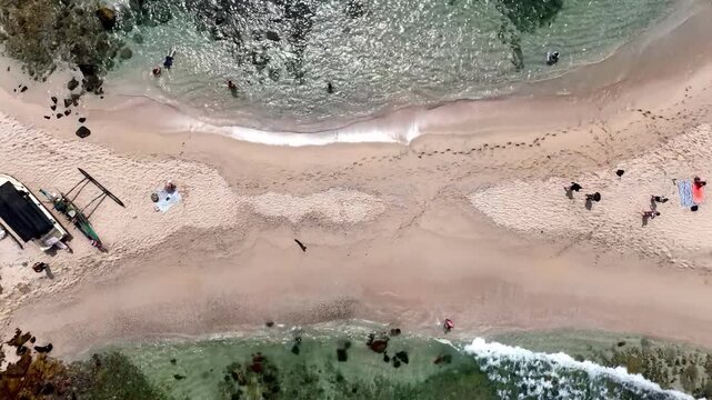 Aerial spiral video above Nilwella Beach in Sri Lanka, revealing turquoise waters, sandy shoreline, tropical vegetation and a stunning Indian Ocean coastline, 4k.