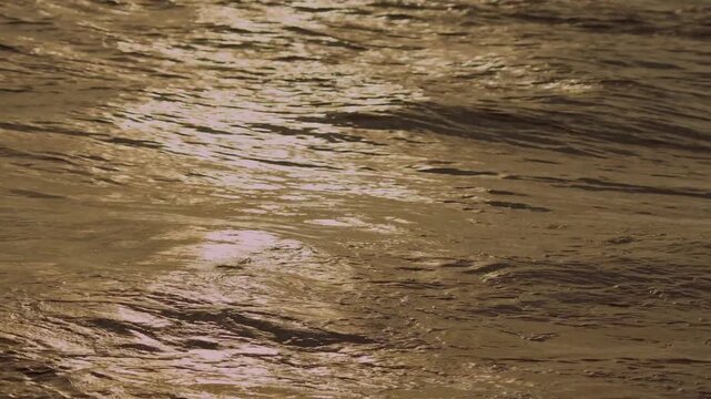 Cinematic aerial video of clear blue ocean water with waves creating natural patterns and textures across the surface, capturing the movement and beauty of the sea, 4k.