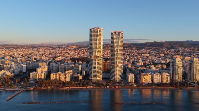 Aerial view of modern skyscrapers and city coastline at sunrise in limassol, cyprus.