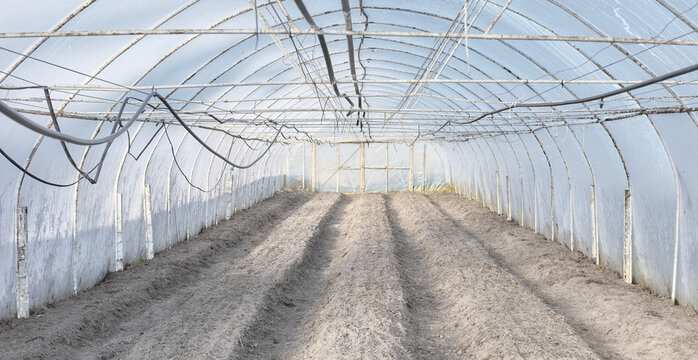 The interior of a greenhouse with soil prepared for planting.