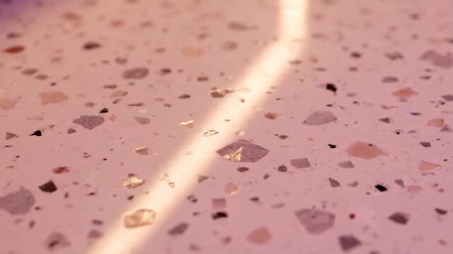 Pink Terrazzo Texture Background with Bright Light Reflection. Abstract Close-up View of Composite Material Surface Featuring Multicolored Stone and Marble Chips.