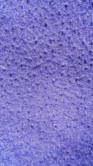 Purple knitted fabric texture close-up with dark speckles and soft wool surface. © Jus