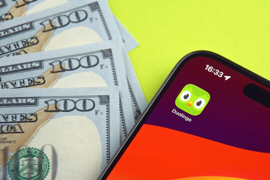 Kharkiv, Ukraine, 7 August 2026: Duolingo app on the smartphone iPhone 15 screen and money