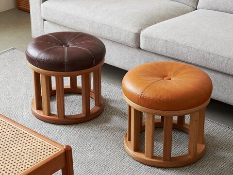 Pair of round leather ottomans with slatted wooden bases
