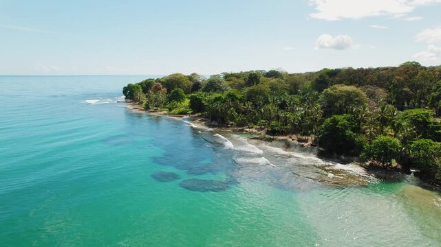 Tropical palm coastline and turquoise sea in Costa Rica on a calm sunny morning