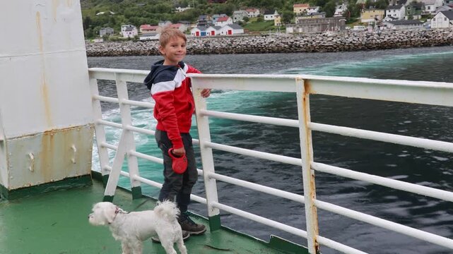 Cute child, enjoying ferry ride between Senja and Andenes Andoya summertime, child and adults on a ferry on sunset