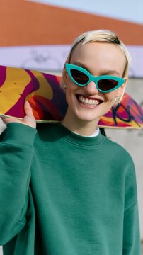 Smiling skateboarder with teal sunglasses and green sweatshirt at urban skatepark for lifestyle portrait background and banner design