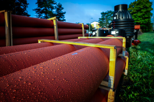 Stacked Red Utility Pipes Await Underground Drainage Installation