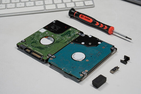 Disassembled Hard Drives and Precision Screwdriver for Data Recovery and Hardware Maintenance