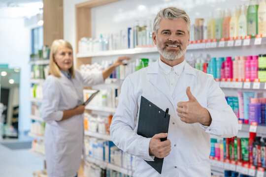 Two pharmacists in lab coats working in a pharmacy