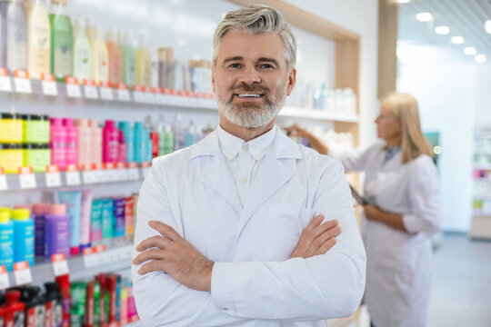 Two pharmacists in lab coats working in a pharmacy
