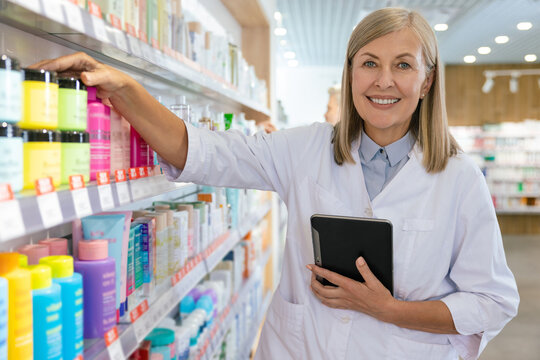 Two colleagues working in the pharmacy and putting the pills on the shelves