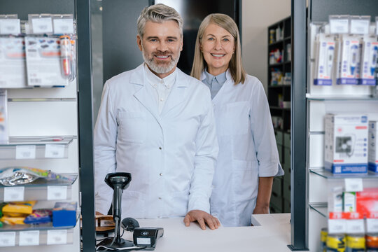Man and woman in lab coats working together in the pharmacy