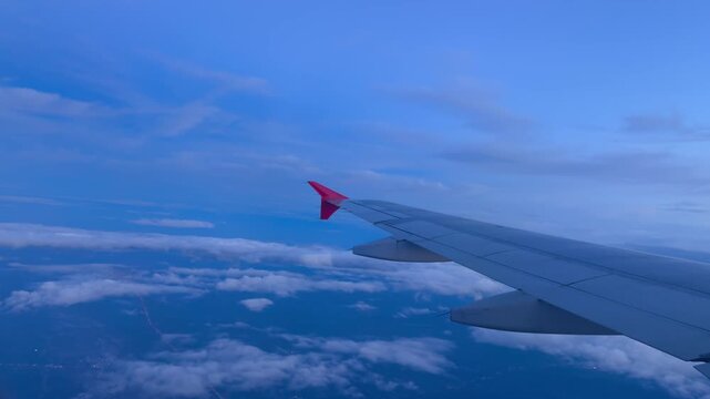 Concluding the departure takeoff sequence the airplane reaches high cruising altitude soaring steadily aloft above a vast blanket of gentle white fluffy clouds under a serene blue twilight atmosphere.