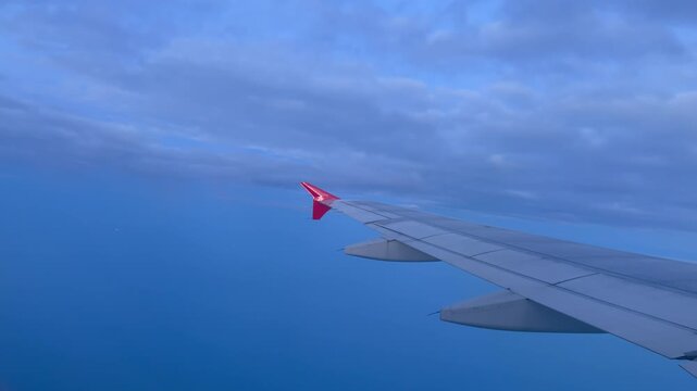 Continuing the scenic upward journey the passenger aircraft steadily climbs higher ascending through the atmospheric cloud layers into a deepening blue twilight sky towards its final cruising altitude