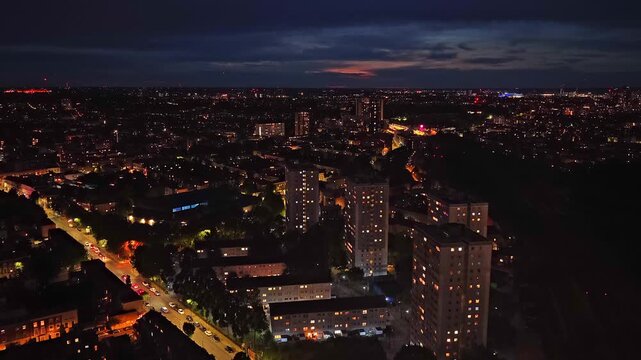 Aerial drone footage of the residential area surrounding Arsenal FC's Emirates Stadium in North London, England, captured at night. The footage shows a cinematic twilight sky and apartment buildings.