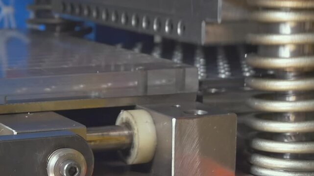 Automated machinery seals medicinal tablets into clear plastic casings, showcasing precision engineering and rhythmic mechanical movement during a daytime factory production run.