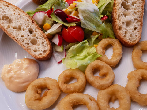 Gebackene Tintenfischringe mit Brot und Salat