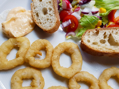 Gebackene Tintenfischringe mit Brot und Salat