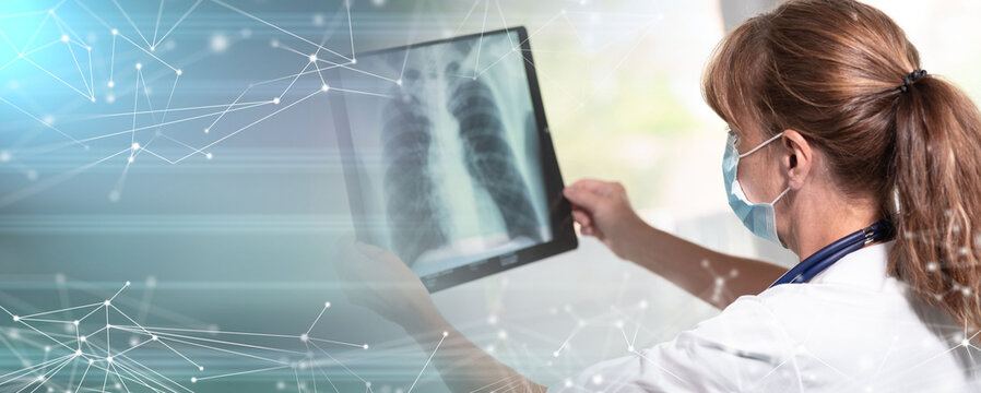 Female doctor examining lungs x-ray during coronavirus outbreak; panoramic banner