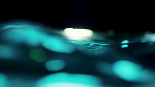 Rippling water surface illuminated by soft light creates a tranquil scene with reflections and gentle waves in a dark environment, showcasing fluid motion and depth