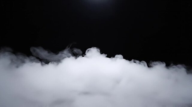 Thick white smoke rolls and billows across the bottom of a solid black background.