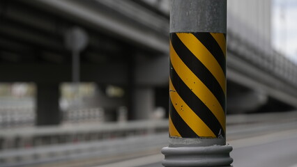 Fototapeta premium Yellow and black safety marked support column on a modern bridge, highlighting transportation infrastructure, urban engineering, construction design and traffic safety elements