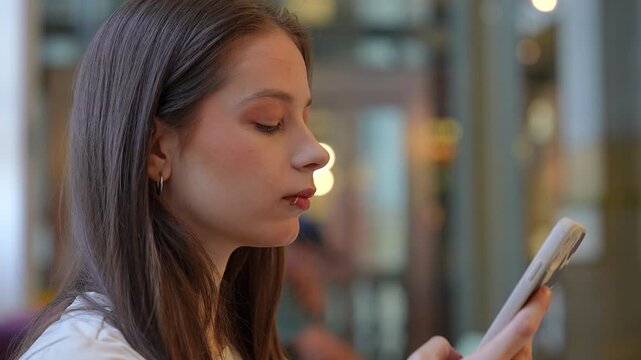 Young woman with lip piercing texting on her smartphone