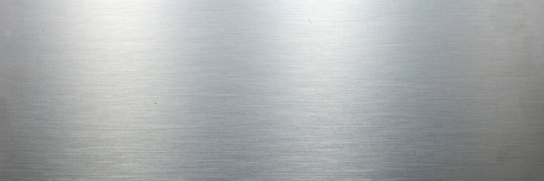 Brushed silver metal texture with horizontal grain, polished stainless steel background with light reflections, industrial metallic surface for sleek modern web design and product backdrops