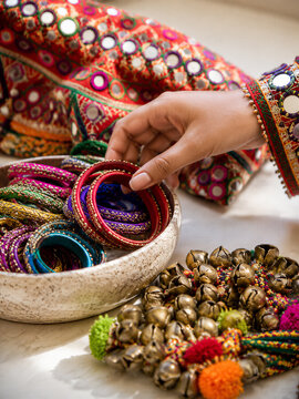 Woman selecting colorful traditional bangles and embellished accessories for Navratri celebration, showcasing Indian festive fashion, cultural decoration, and religious festival preparation