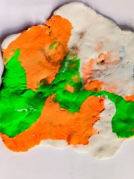 Abstract colorful clay texture background with bright green, orange, and white colors, handcraft clay art surface close-up.
