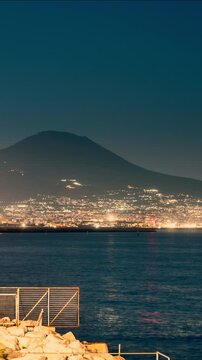Naples and the coast facing Mount Vesuvius at night, harbor traffic