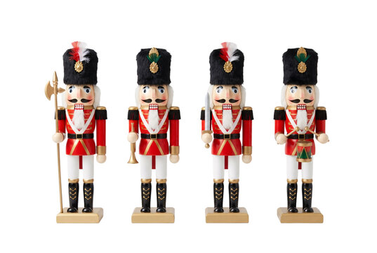 Four traditional wooden nutcracker soldier figurines in red military uniforms holding weapons and instruments