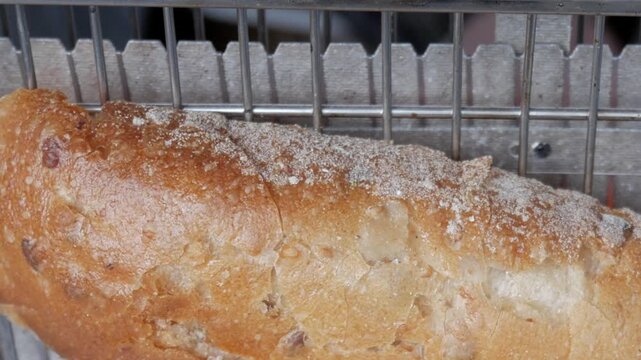 Slice of bread on vertical toaster. Incandescent heating elements glowing orange behind