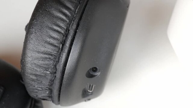 Black headphones next to white headphones on white table. Wireless via bluetooth audio technology.