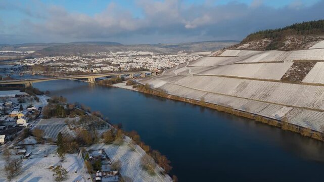 Snow covered Moselle valley, vineyards and Mosel river, Viaduct Longuich bridge of highway crossing near Trier, aerial view, winter season with frost in Germany