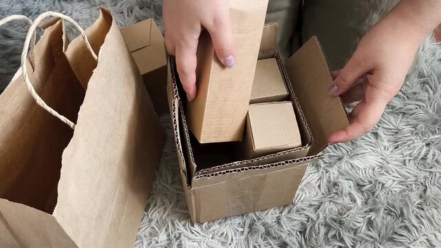 Woman sorting cardboard boxes, paper bags and paper waste for recycling, household waste separation and environmental protection concept.