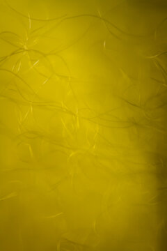 Extreme macro of polyester stable fiber on yellow background. Selective focus, shallow depth of field. Abstract dreamy background