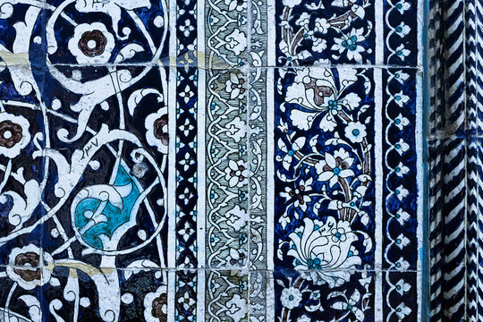 Ornate blue and white ceramic tilework with floral arabesque patterns at Pahlavan Mahmud Mausoleum in Khiva. Detailed close-up of traditional glazed tiles ideal for cultural heritage and design.