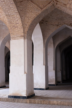 Vaulted brick interior of Kalyan Mosque in Bukhara with rows of plastered pillars and pointed arches. Ideal for travel publications and architectural reference materials.