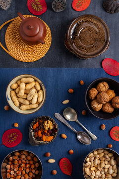 Food themed still life with crockery, various nuts and tea. Flat lay. Top view.